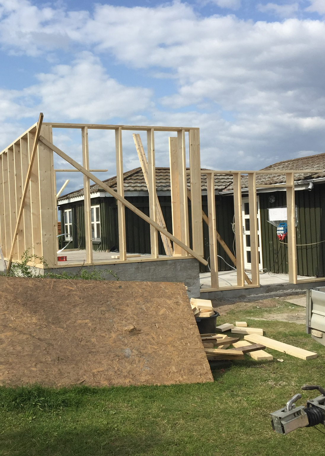 Foto af et træskelet til en tilbygning sat på et fundament i to niveauer for at udnytte den flotte udsigt fra sommerhuset, tilbygningen skal bygges sammen med